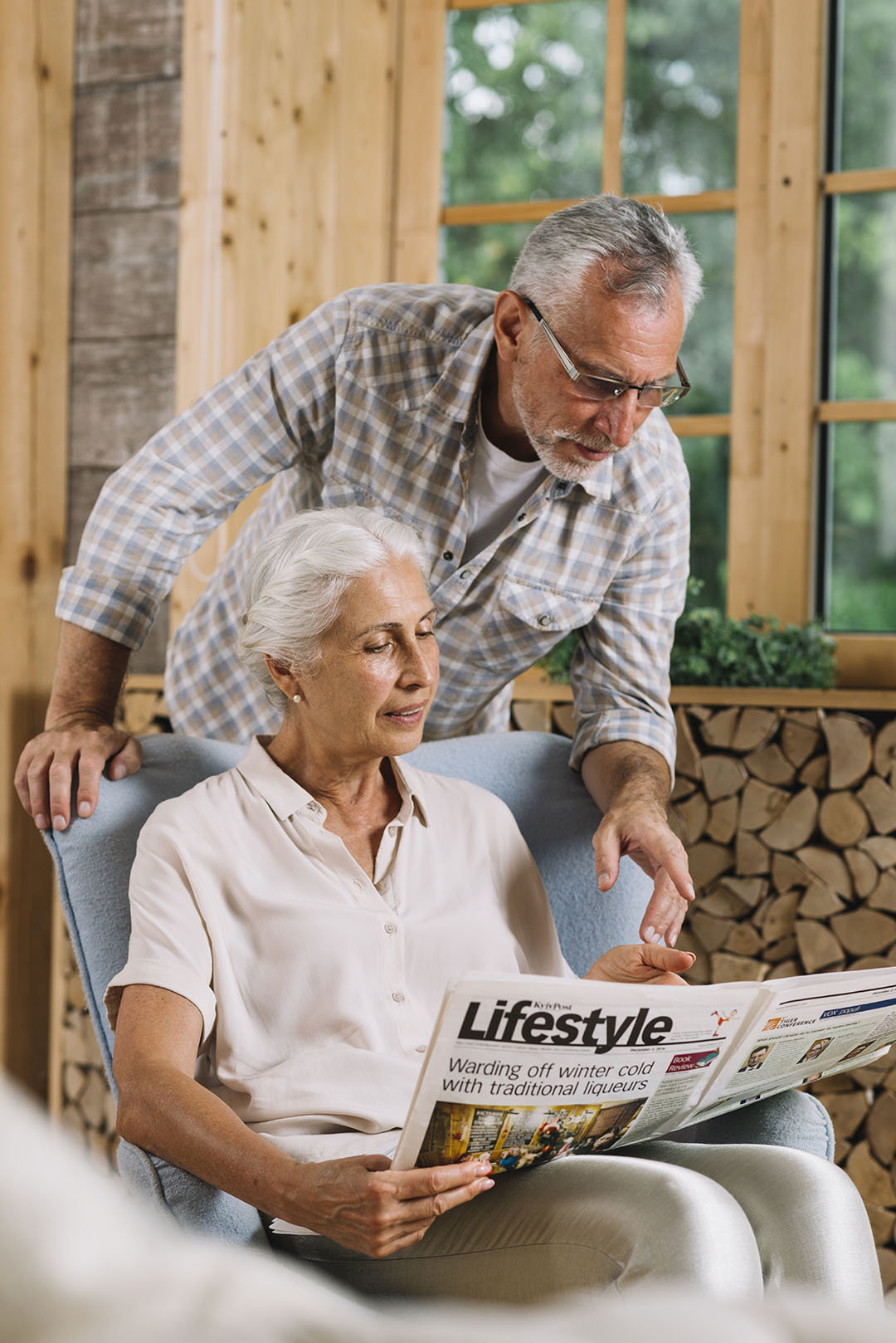 senior-man-pointing-newspaper-hold-by-her-wife